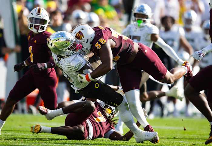 Arizona State Sun Devils defensive lineman B.J. Green tackles Oregon running back Bucky Irving.